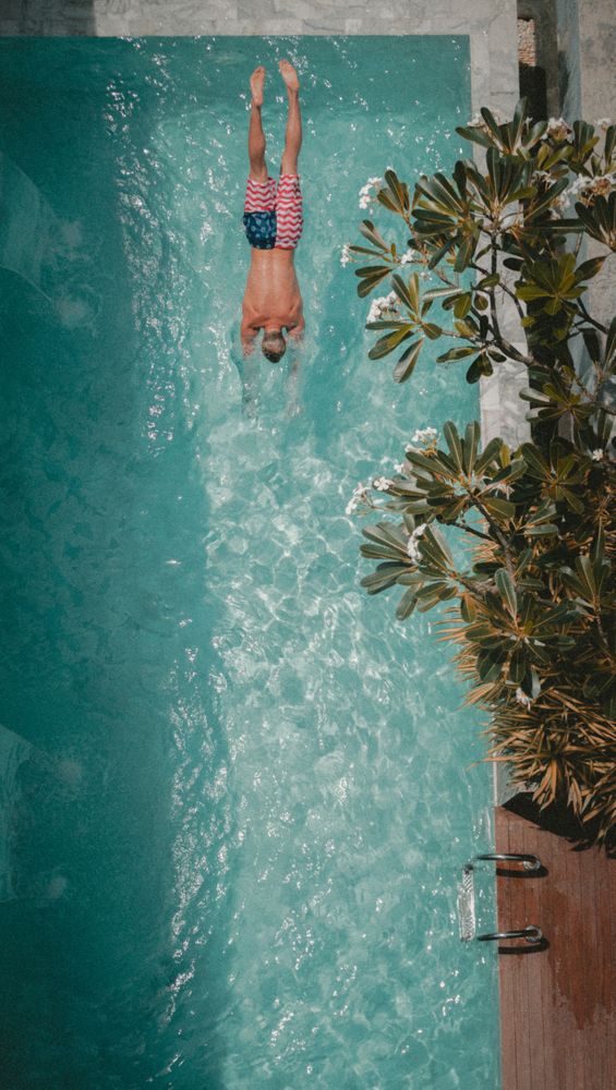 High angle view of man swimming with the US flag as bathing suit in swimming pool