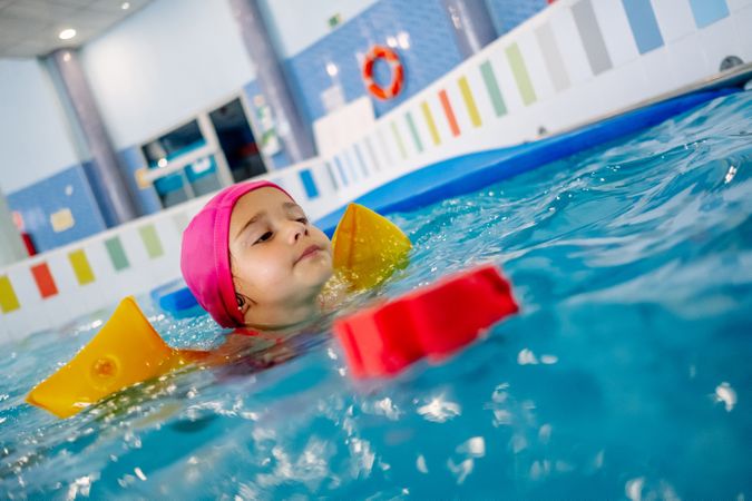 girl with water wings in swimming pool