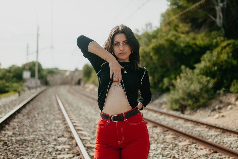 Excited woman showing tattoo on railway