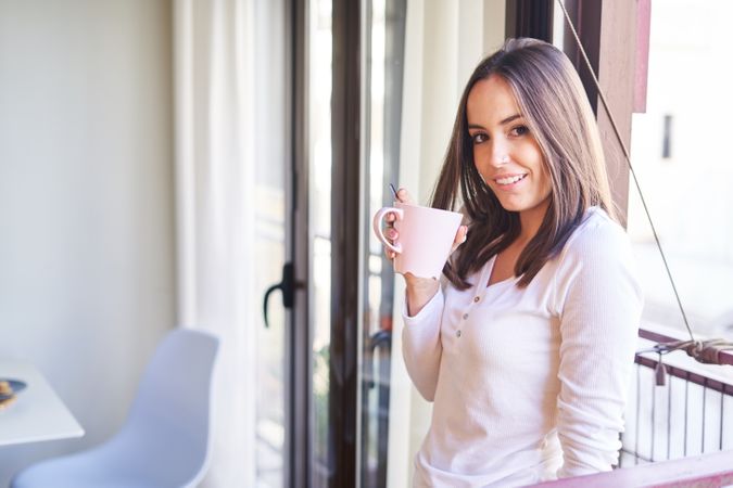 Smiling woman eating at table at home