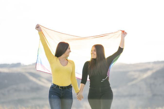 Young female couple with rainbow flag