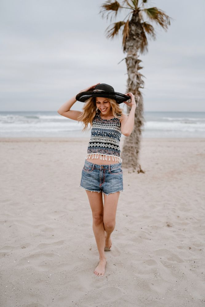 Young female relaxing on beach with hat