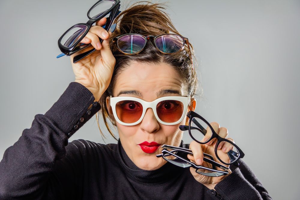Woman with various glasses and red lips gesturing
