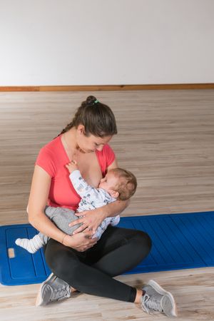 Mother feeding baby in gym
