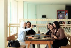 A Group of Asian  College Student Take Selfie Photo While Stduying Together using Mobile Phone