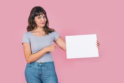 woman pointing at a blank whiteboard against a pink background