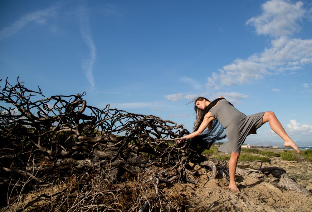 Woman posing on twigs of dry trees