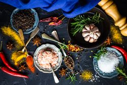 Spices and herbs in teal bowls on counter