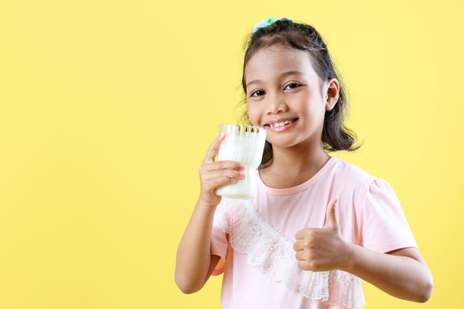 Cheerful Little Asian Girl Drinking Milk