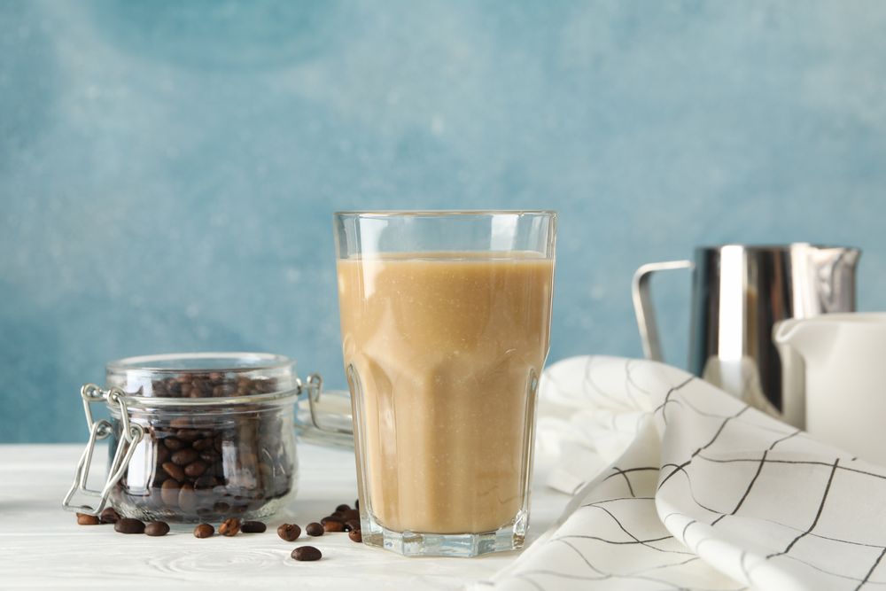 Composition with glass of ice coffe on wooden table