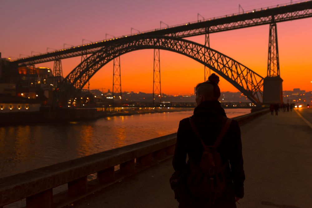 Woman looking at river and city in evening