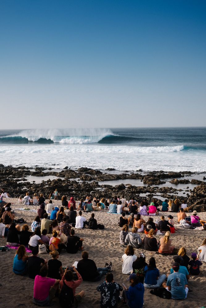 Group of people on beach watching waves crashing