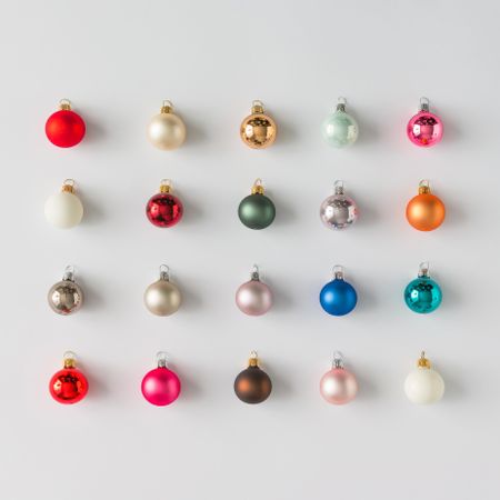 Rows of colorful Christmas bauble decorations on light background