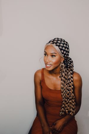 Black woman wearing headscarf and brown dress