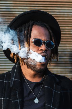 Trendy Black man in hat smoking