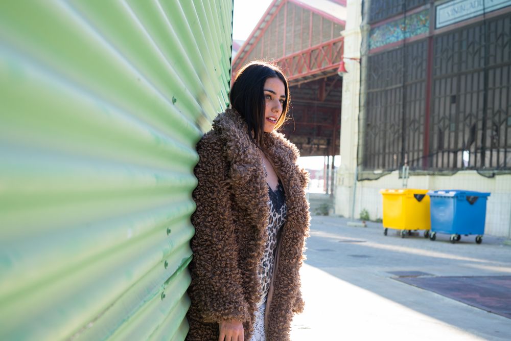 Stylish female near green wall
