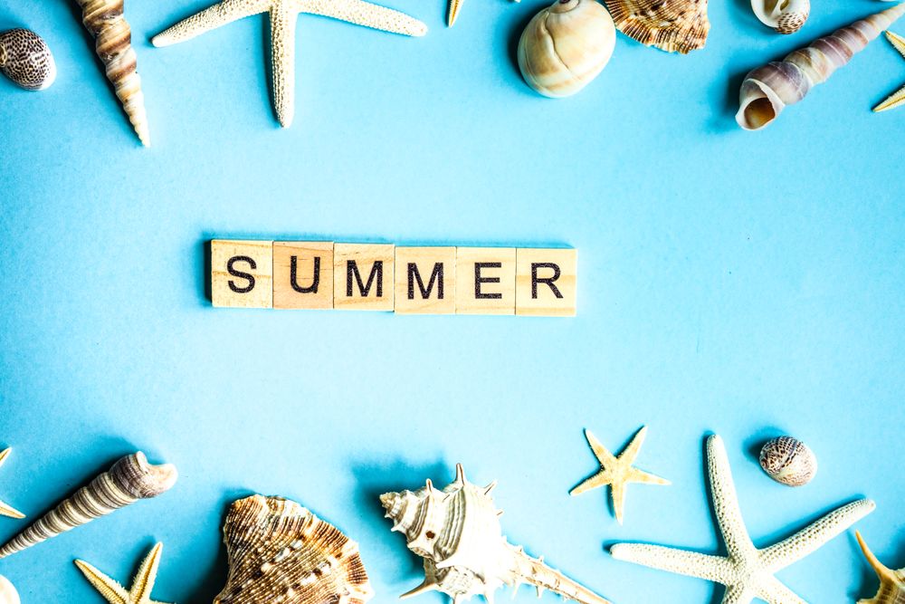 "Summer" on blue table with sea shells