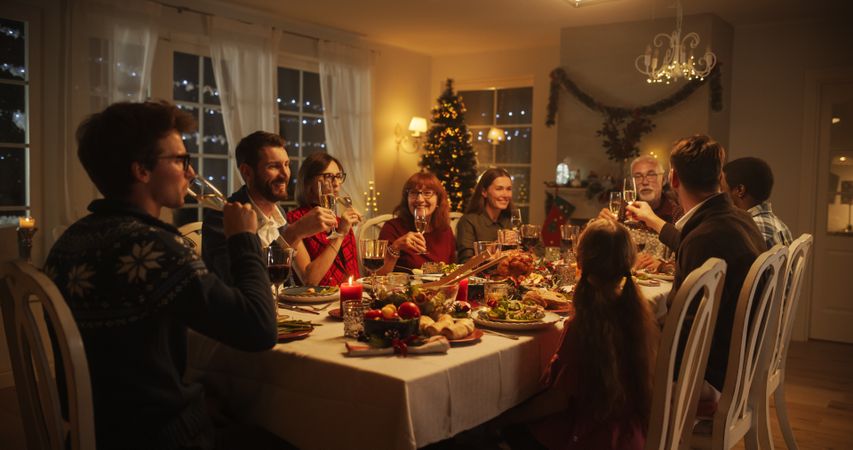 Christmas Evening Celebration at Home with Multicultural Group of Loved Ones Enjoying a Turkey Dinner.