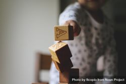 Child playing with wooden cubes that has letters on them 0yOQO4