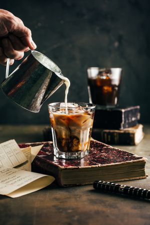 Pouring milk in a cold espresso coffee glass