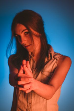 woman with piercing in nose making gun gesture with hands