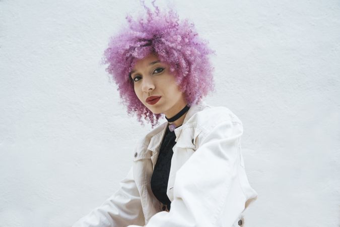 Stylish woman with pink hair looking at camera