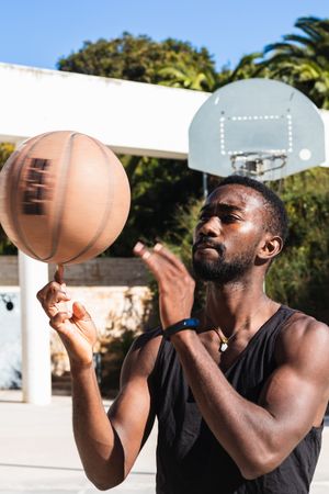 Black man spinning basketball on finger