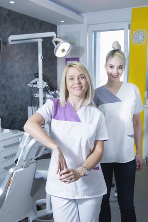 Two blonde female dentists in their bright office, vertical