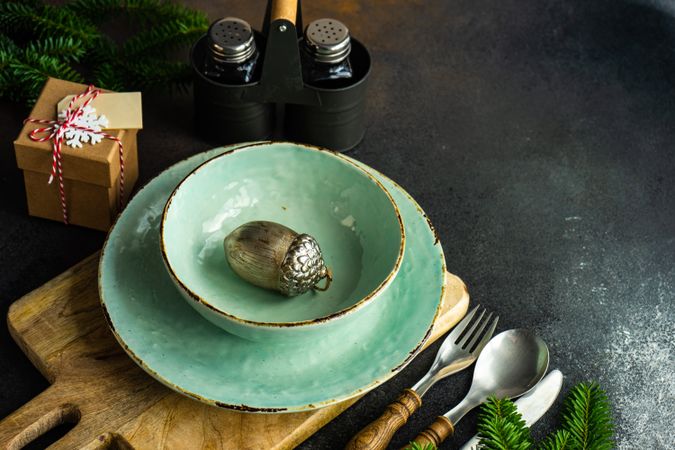 Light green table setting with bowl and plate and holiday ornament