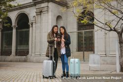 Two young Asian tourist women looking at phone 4d7aN5