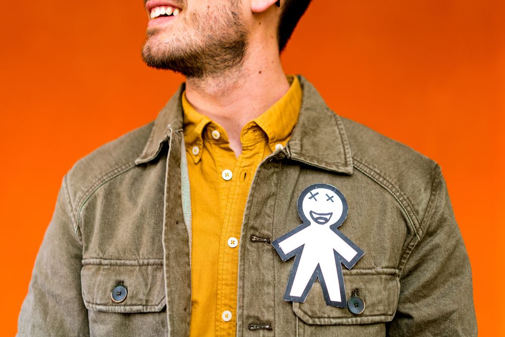 Smiling man with funny paper toy on jean jacket