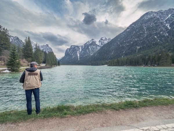 Male photographer near mountains and lake