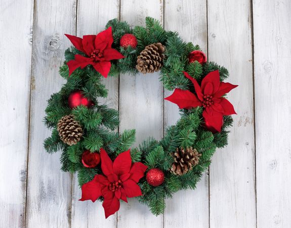 Holiday Poinsettia Christmas wreath on rustic wooden boards