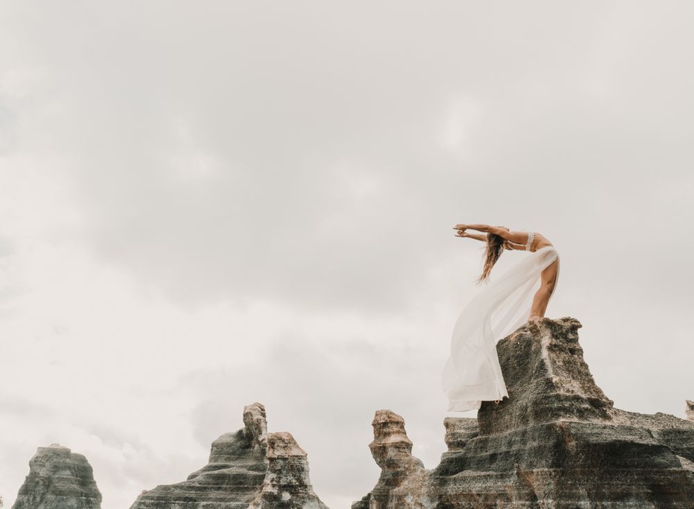 Anonymous female exercising on top of rock