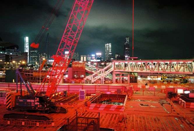 Red metal crane near city during night time