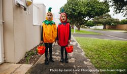 Children in pumpkin costumes trick-or-treating on Halloween 5o9L9b