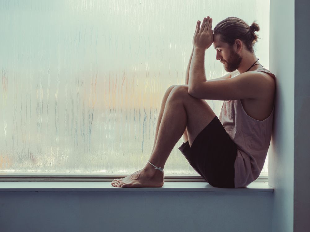 Man in mindfulness on window sill
