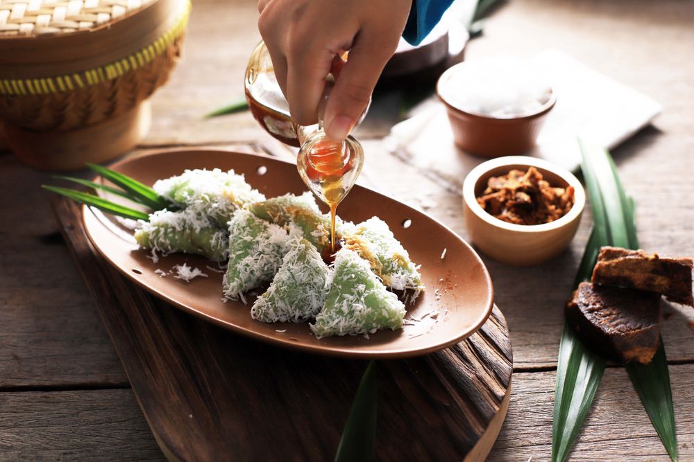 Lupis, Indonesian Traditional Snack Made From Sticky Rice, Wrapped with Banana Leaf, Shape Triangle  Served with Liquid Palm Sugar and Grated  Coconut