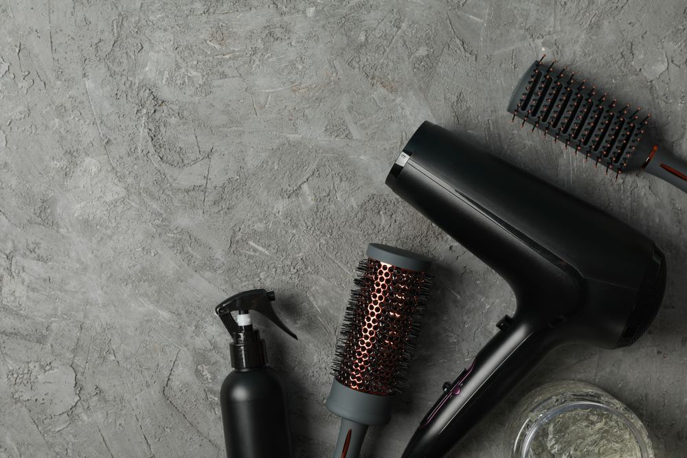 Composition with hairdresser accessories on gray background, space for text