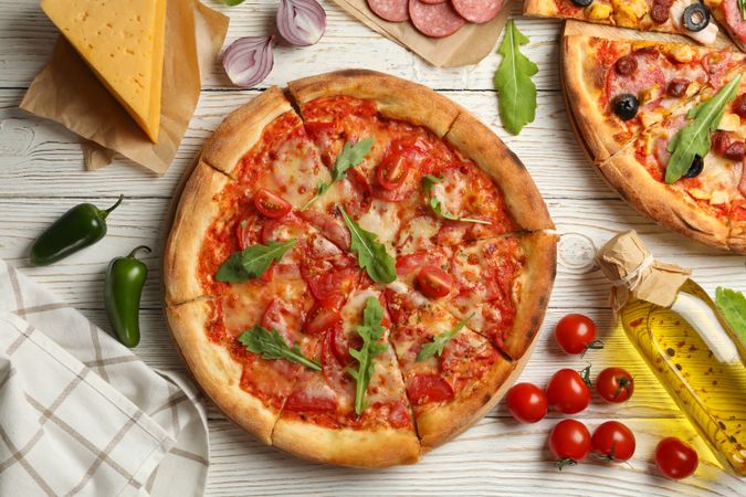 Tasty pizza and ingredients on wooden background