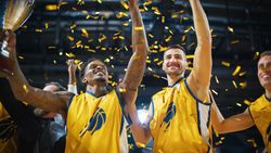 Multiethnic Basketball Players Celebrate Championship Victory with Hugs, Jumping, Holding the Trophy High.