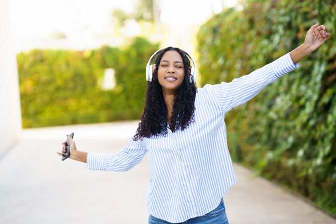 A Joyful Young Woman Happily Enjoying Her Music Outdoors While Wearing Headphones