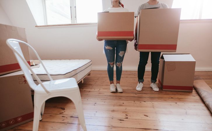 Cropped shot of young couple carrying packed boxes into new studio loft