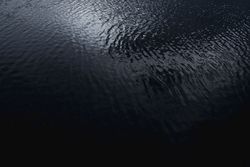 Dark ribbed water surface reflecting the sky