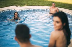 Friends sitting on edge of pool