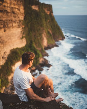Traveler on high cliff viewing ocean