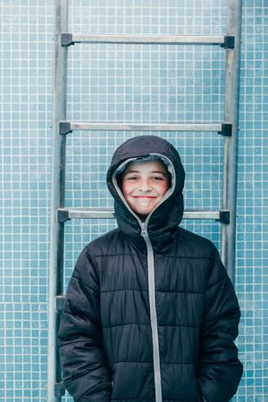 Boy in warm clothes standing in empty pool