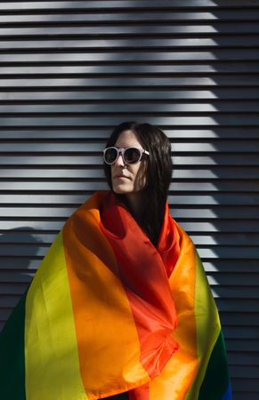 White Woman posing happily with the LGBTQ flag