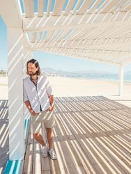 Relaxed man standing in gazebo on beach