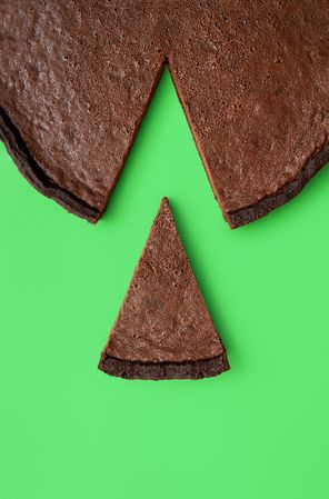 Chocolate tart slice, isolated on a green background